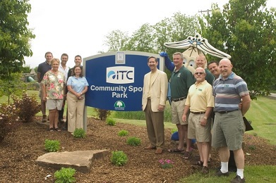 ITC Park sign with people standing around it